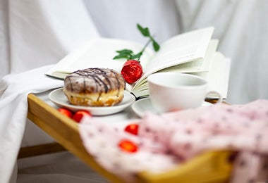 Bandeja con café, donut y rosa, desayuno en la cama para San Valentín 