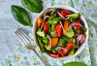 Ensalada con base de hojas verdes, con zanahoria y cebolla, una comida fácil de hacer. 