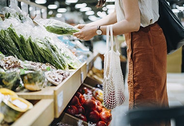 Mujer comprando ingredientes envueltos en papel film