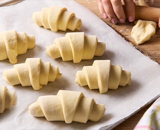 Siete croissants de almendras listos para hornear