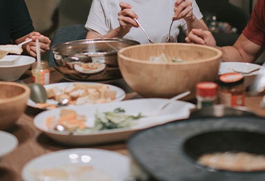 Familia compartiendo dumplings y otros platillos asiáticos 