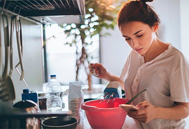 Mujer preparando galletas fáciles mirando receta