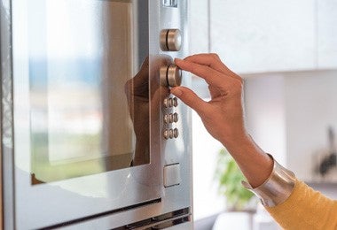 Persona manipulando el horno para cocinar filetes de lubina.