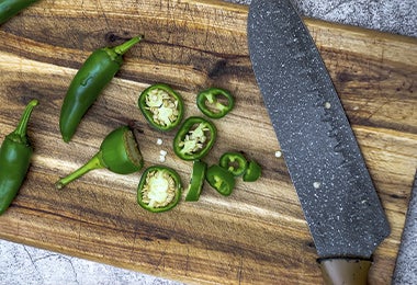 Jalapeños verdes para preparar ají casero cortados en rodajas con un cuchillo de cerámica