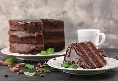  Un naked cake de chocolate y frutos secos, con una rebanada cortada y servida en un plato. 