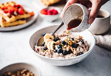 Plato de porridge con banano, arándanos y miel