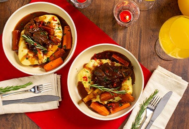 Cama de polenta con carne y vegetales encima.