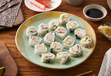 Rollos de sushi california acompañados con salsa de soya y jengibre encurtido