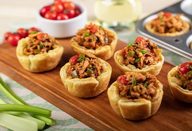 Tapas españolas con pimientos, carne y verduras en una tabla de madera.