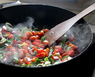 Verduras frescas cocinándose en wok para hacer chutney de mango y otras variantes