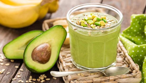 Aguacate partido a la mitad con un batido de cereal y verduras para desintoxicar el cuerpo