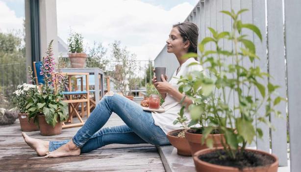 Una mujer con un vaso y un plato de comida aprovechando un buen descanso.