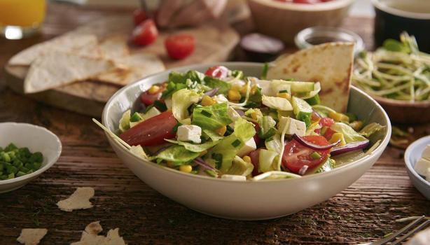 Ensalada mediterránea en una mesa con diferentes acompañamientos