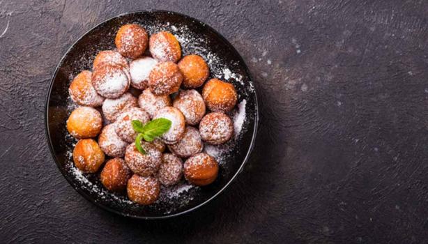 Plato de buñuelos de yuca espolvoreados vistos desde un ángulo cenital