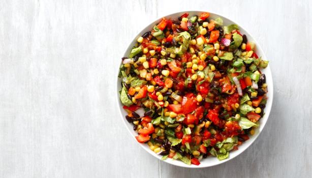 Ensalada marroquí colorida con tomate, maíz, pimiento y hierbas frescas