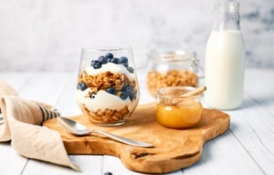 Desayuno saludable para alimentarse bien dentro y fuera de casa. Granola con yogurt griego y miel para alimentarse saludablemente.
