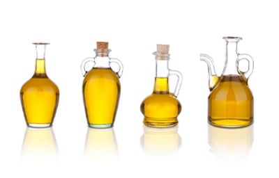 Tipos de aceite de cocina, variedad y sabor. Cuatro tipos de aceite de cocina en recipientes de vidrios distintos.