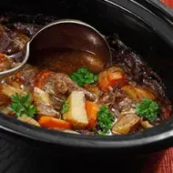 Estofado de carne y verduras siendo preparado en una olla de cocción lenta. Estofado de carne y verduras siendo preparado en una olla de cocción lenta.
